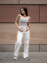 A woman wears striped vest and jeans